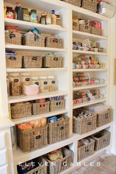 an organized pantry with wicker baskets and food items on the shelves, along with other storage bins