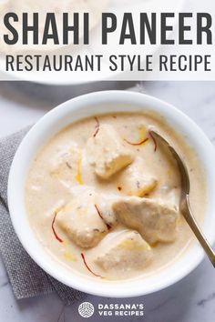 a white bowl filled with food on top of a marble counter next to a silver spoon