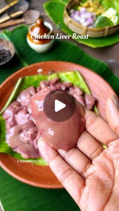 a person holding a small food item in their hand on top of a green plate