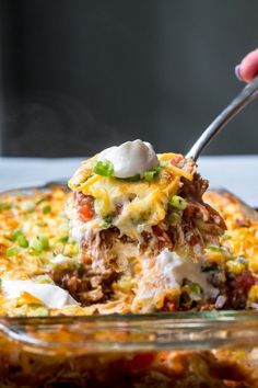 a person scooping food out of a casserole dish