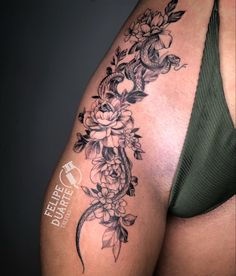 a woman's thigh with flowers and vines on the side, in black and white