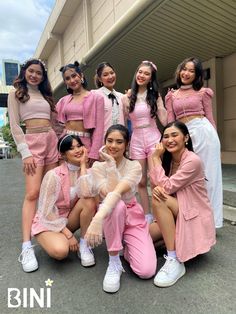 a group of women in pink outfits posing for a photo