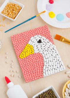 an image of a duck made out of beads on a table with other crafting supplies