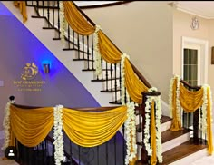 a staircase decorated with yellow drapes and white flowers