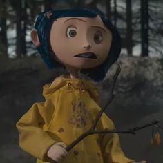 the doll is wearing a yellow raincoat and holding a branch in front of her face