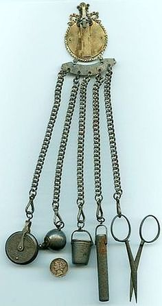 an assortment of old metal items hanging from chains and hooks on a white surface,