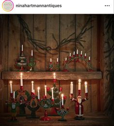 a wooden shelf filled with candles and figurines on top of a wooden table