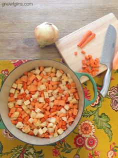 chopped carrots and onions in a bowl next to a cutting board