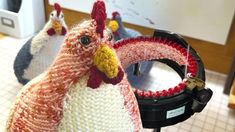 three knitted chickens sitting on top of a table