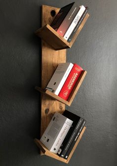 two wooden shelves with books on them against a gray wall, one holding several books