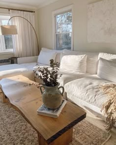 a living room filled with furniture and a wooden table in front of a white couch