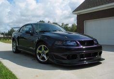 a black car parked in front of a garage