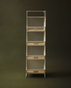 a tall metal shelf with baskets on it's sides, against a dark background