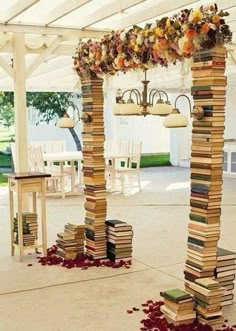 a bunch of books stacked on top of each other under a white tented area