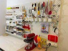 a kitchen counter with many utensils hanging on the wall