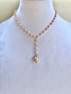 Beautiful and feminine pink hued pearl necklace with gold accents, and a large baroque pearl pendant. Long Drop Pearl Necklace With Pearl Pendant, Long Drop Pearl Necklace With Pearl Charm, Lariat Necklace With Baroque Pearl Chain, Long Drop Pearl Necklace, Pink Baroque Pearl Single Strand Necklace, Pink Single Strand Baroque Pearl Jewelry, Pink Single Strand Baroque Pearl Necklace, Elegant Pink Pearl Drop Necklace, Elegant Pink Pearl Necklace With Pendant