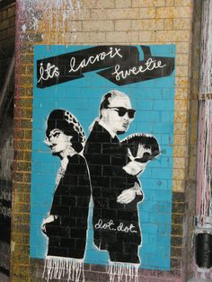 a painting on the side of a building with two people wearing hats and scarfs