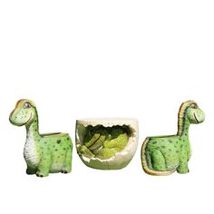 three green dinosaur shaped planters sitting next to each other