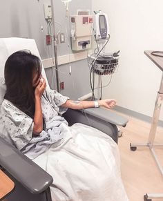 a woman laying in a hospital bed talking on the phone