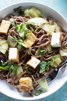 sesame lime soba noodles with tofu and cucumbers in a white bowl