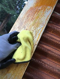 a pair of gloves on top of a rusted piece of metal next to a yellow cloth