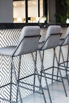 four chairs are lined up in front of a bar