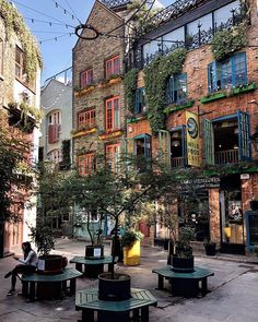 an image of a city street with tables and benches