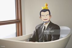 a paper cut out of a man in a suit and tie with a rubber ducky on his head