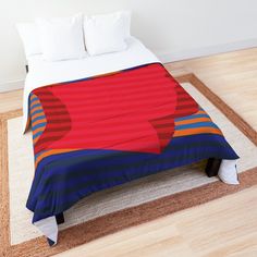 a bed with a red, blue and orange comforter on it's side