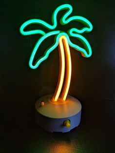 a neon palm tree is on display in a dark room with the light turned on