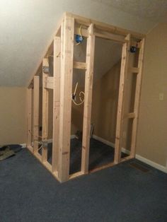 an unfinished room with some wood framing on the walls and carpeted flooring in front of it