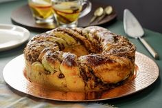 a bundt cake sitting on top of a plate next to silverware and cups