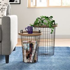 two wire baskets with magazines on them are sitting in front of a couch and coffee table