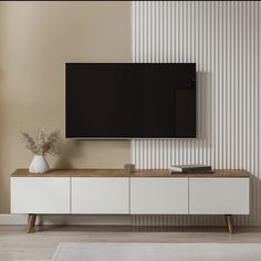 a flat screen tv mounted to the side of a white cabinet in a living room