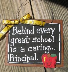 a wooden sign that says behind every great school is a caring principals with a measuring tape on it