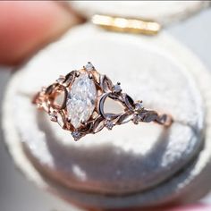 a close up of a person holding a ring with a diamond in it's center