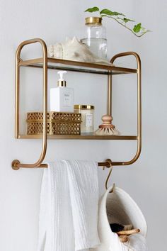 a bathroom shelf with towels, soap and other items hanging on the wall next to it