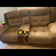 a brown reclining couch with two cups on the armrests next to it