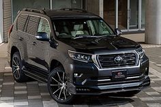 a black suv parked in front of a building on a checkerboard pattern floor