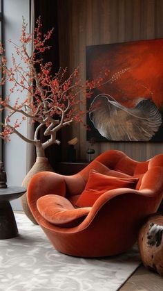 an orange chair sitting on top of a rug next to a vase filled with flowers