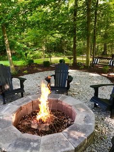 an outdoor fire pit with chairs around it