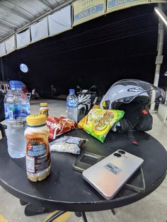 the table is covered with sports equipment and water bottles, snacks, and other items