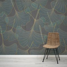 a chair sitting in front of a wall with a large leaf pattern on it's side