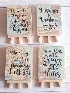 four small wooden eases with hand painted words on them, each holding a map