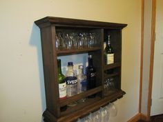 a wooden shelf filled with wine glasses and bottles