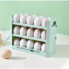 an egg carton filled with white eggs on top of a table next to a glass of orange juice