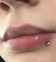 a woman's nose with a tiny diamond on the tip of her lip,