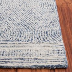 a blue and white area rug on a wooden floor with wood floors in the background