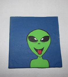 a green alien with black eyes and tongue sticking out its tongue is painted on a blue background