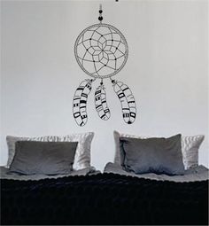 a wall decal with a dream catcher hanging from it's side in a bedroom